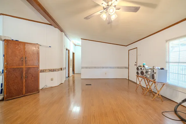 a kitchen with stainless steel appliances granite countertop a refrigerator a sink dishwasher a stove and white countertops with wooden floor