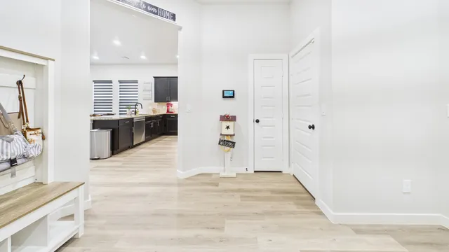 a view of a hallway with wooden floor and furniture