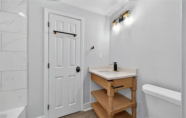 a bathroom with a sink toilet a mirror and vanity