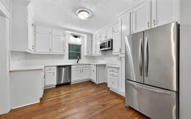 a kitchen with stainless steel appliances white cabinets and a refrigerator