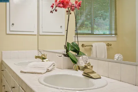 a bathroom with a granite countertop sink toilet a large mirror a bathtub and shower