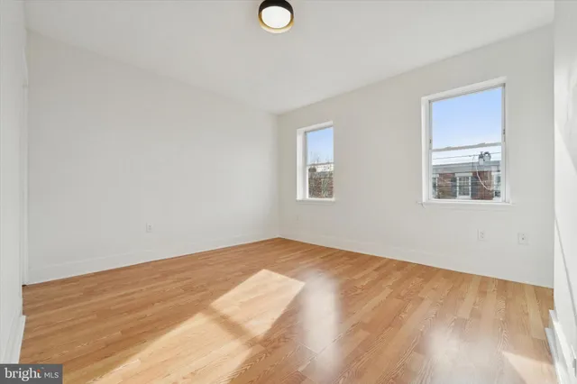 a view of empty room with wooden floor