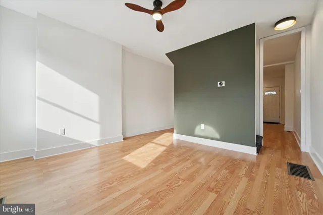 a view of a big room with wooden floor and windows