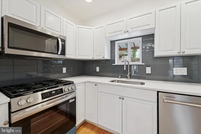 a kitchen with cabinets stainless steel appliances and a sink