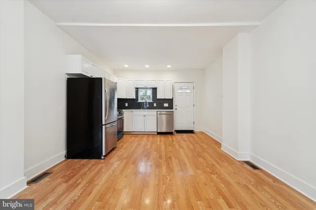 a view of a kitchen with a sink and wooden floor