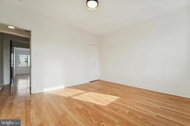 a view of empty room with wooden floor