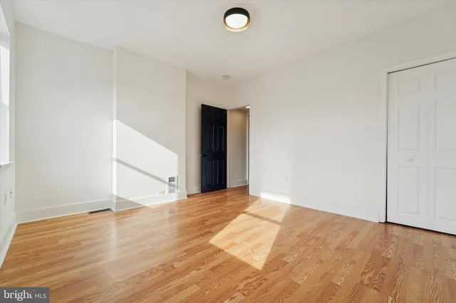 a view of an empty room with wooden floor