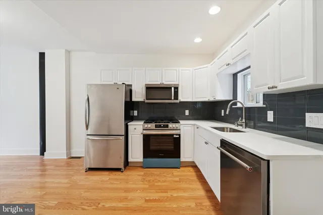 a kitchen with a sink a microwave a refrigerator and cabinets