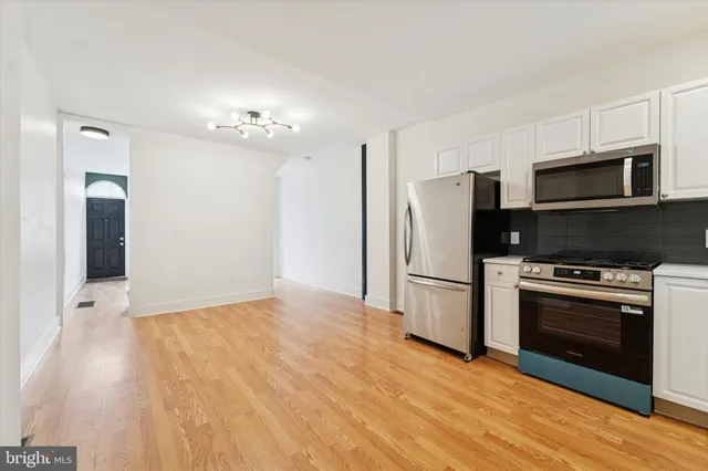 a kitchen with stainless steel appliances a stove a refrigerator and a microwave