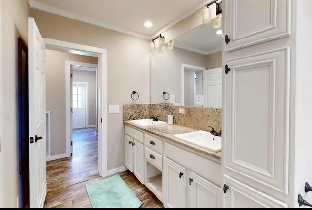 a spacious bathroom with a double vanity sink a mirror and a shower