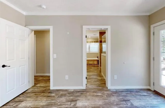 an empty room with wooden floor and a bathroom