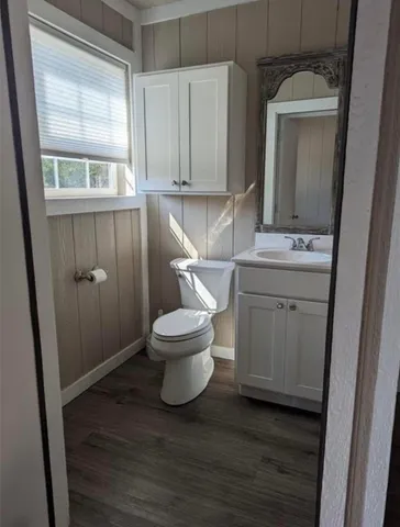 a bathroom with a toilet sink and mirror
