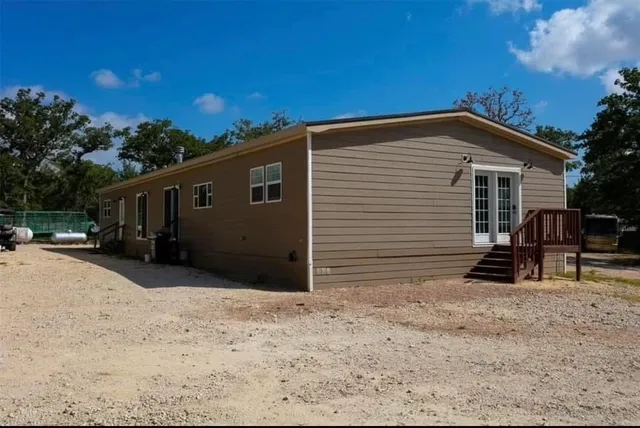 a view of house with backyard and sitting area
