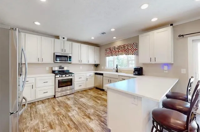 a kitchen with white cabinets and stainless steel appliances