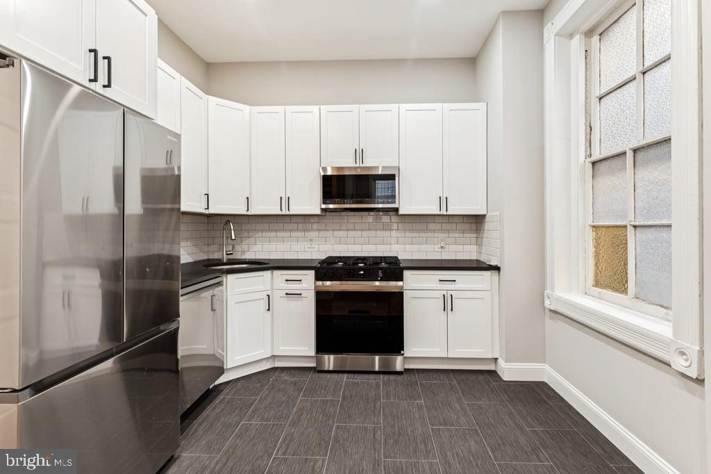 2101 Spruce Street, Unit 2R Philadelphia, PA 19103 - Photo 11 of 28 a kitchen with stainless steel appliances granite countertop a stove a refrigerator and a microwave