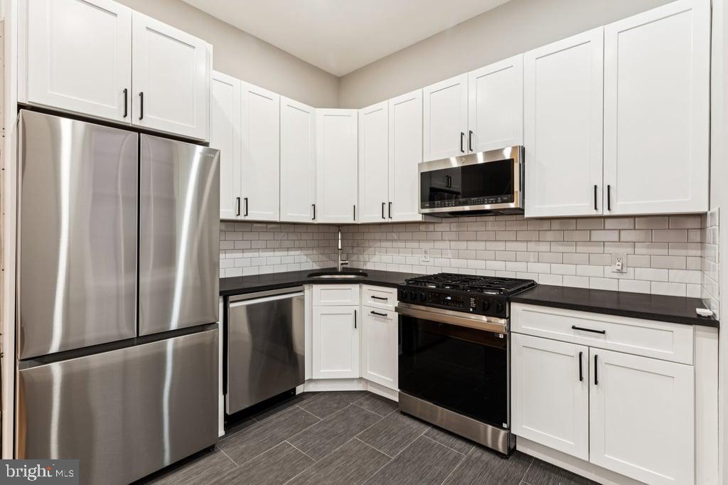2101 Spruce Street, Unit 2R Philadelphia, PA 19103 - Photo 12 of 28 a kitchen with cabinets stainless steel appliances and a sink