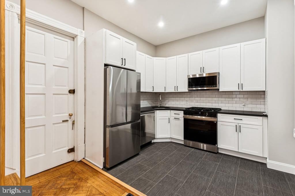 2101 Spruce Street, Unit 2R Philadelphia, PA 19103 - Photo 14 of 28 a kitchen with stainless steel appliances granite countertop a refrigerator stove and sink