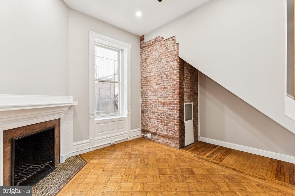 2101 Spruce Street, Unit 2R Philadelphia, PA 19103 - Photo 18 of 28 a view of an empty room with exposed radiator and fireplace