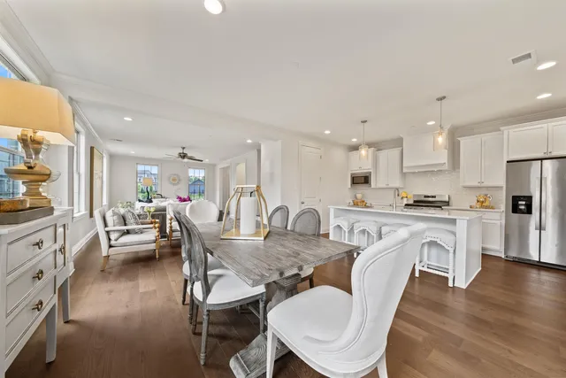 a view of a dining room with furniture a rug and wooden floor