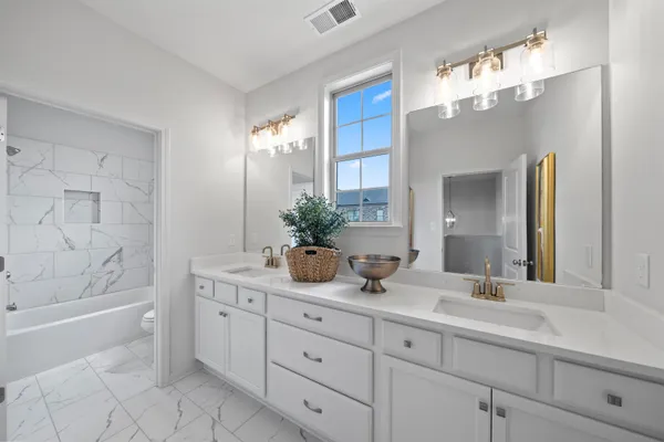 a bathroom with a sink a large mirror and a bathtub