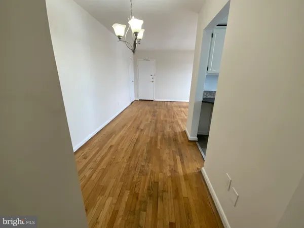 a view of a hallway with wooden floor