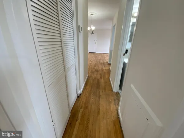 a view of a hallway with wooden floor and stairs