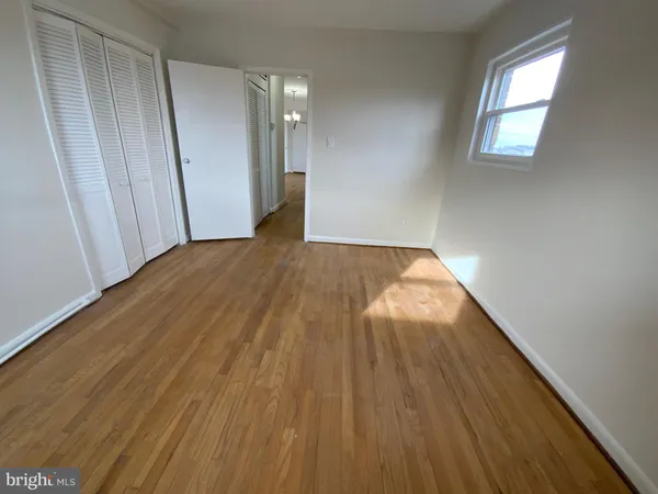 a view of empty room with wooden floor