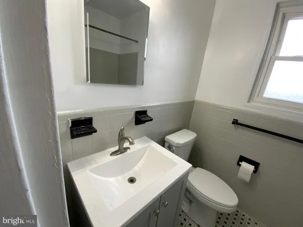 a bathroom with a sink a toilet and mirror