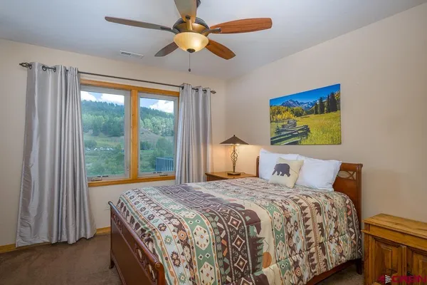 a bedroom with a bed and a large window