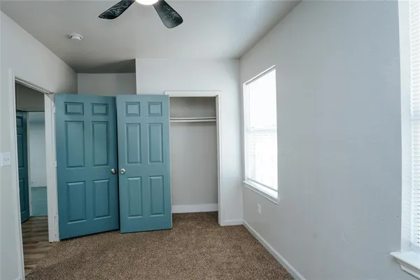 an empty room with closet and windows