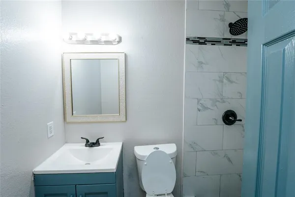 a bathroom with a toilet a sink a mirror and vanity