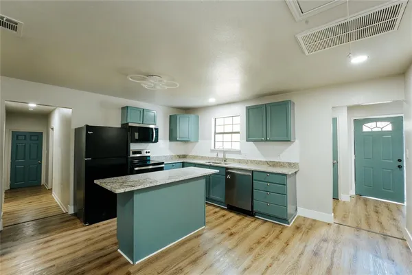 a kitchen with stainless steel appliances granite countertop a sink and cabinets