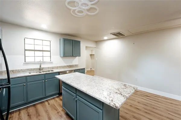 a kitchen with a sink and a wooden floor