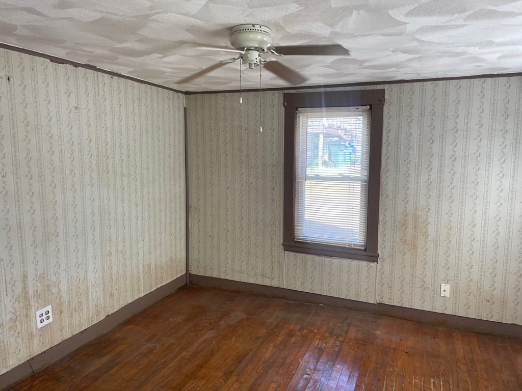 3216 North Main Street Fall River, MA 02720 - Photo 2 of 42 an empty room with wooden floor chandelier fan and windows
