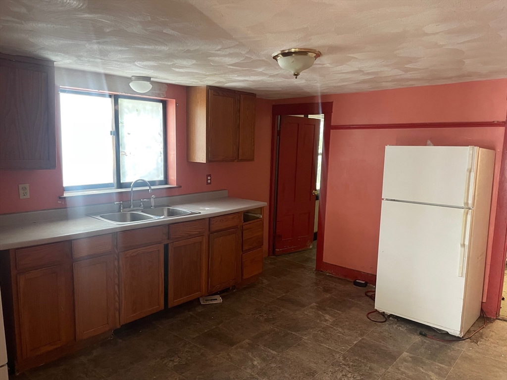 3216 North Main Street Fall River, MA 02720 - Photo 8 of 42 a kitchen with stainless steel appliances granite countertop a refrigerator and a sink