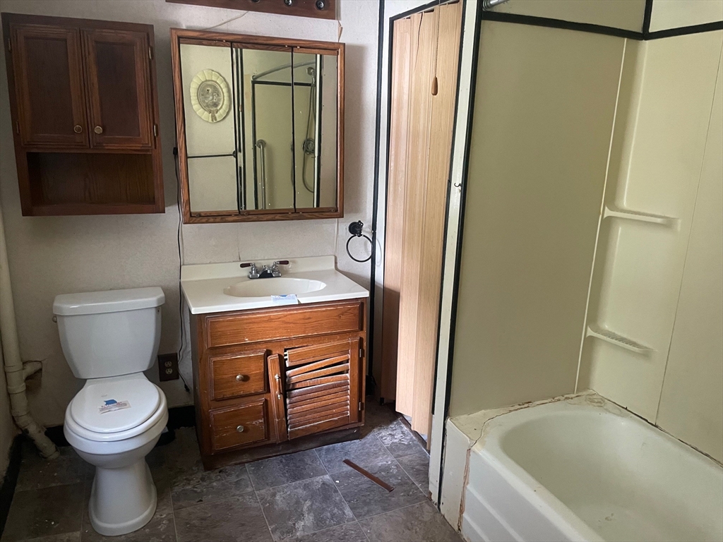 3216 North Main Street Fall River, MA 02720 - Photo 10 of 42 a bathroom with a sink a toilet and a mirror