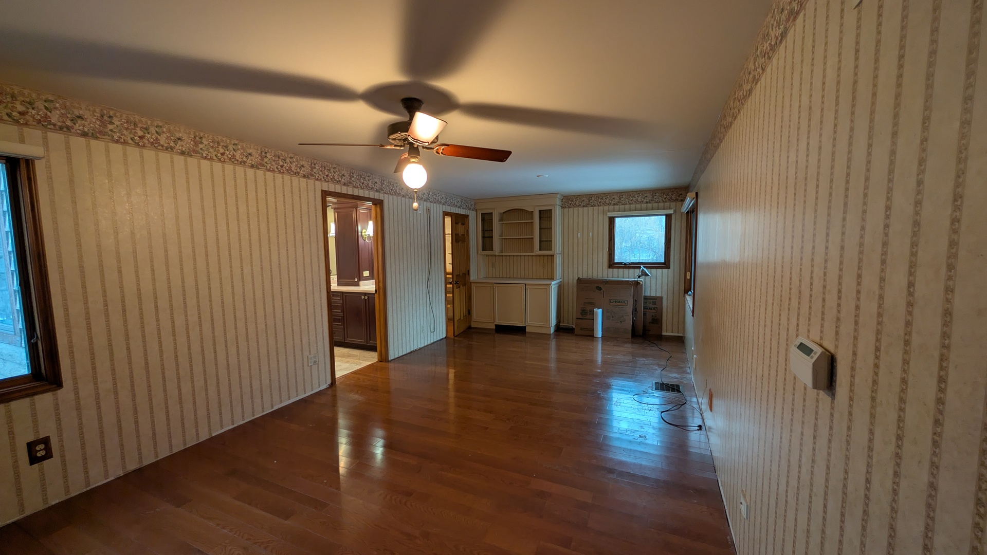 1102 O'Plaine Road Waukegan, IL 60085 - Photo 22 of 41 a view of a livingroom with furniture wooden floor ceiling fan and windows