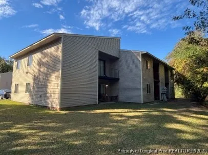 a view of a house with backyard and trees