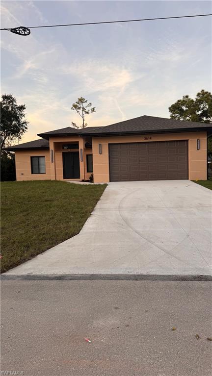 a front view of a house with a yard and garage