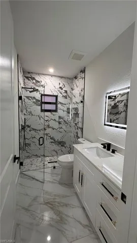a bathroom with a sink mirror and shower