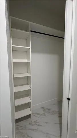 a view of walk in closet with empty racks