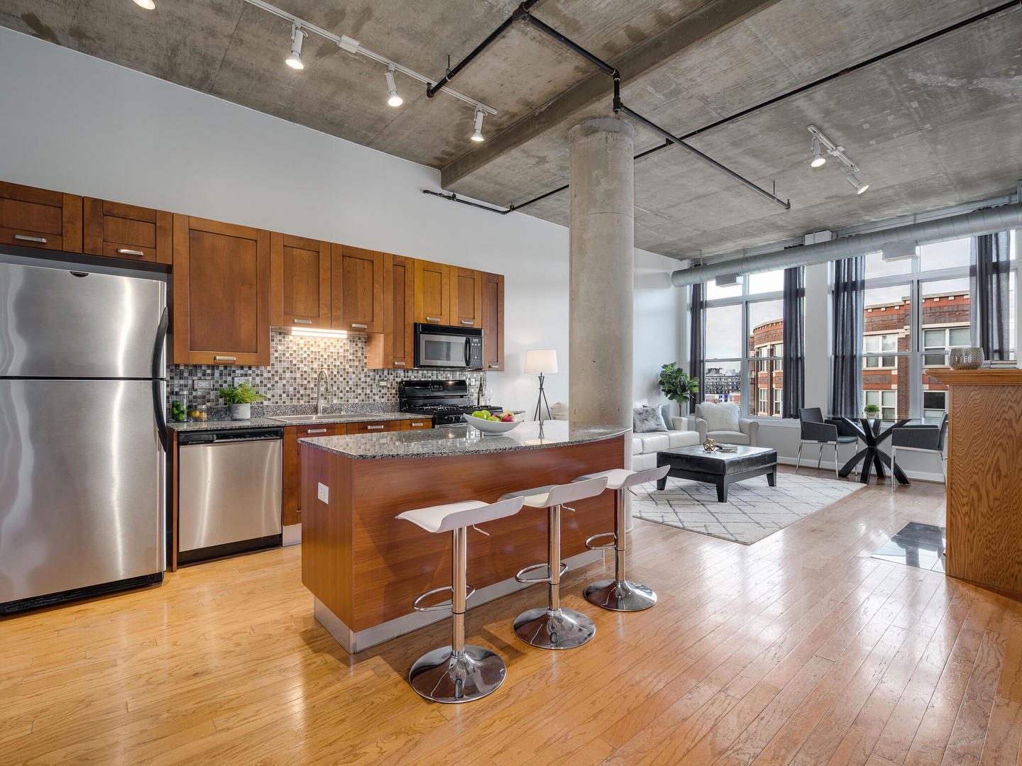 111 South Morgan Street, Unit 811 Chicago, IL 60607 - Photo 3 of 21 a kitchen with stainless steel appliances granite countertop a refrigerator a sink dishwasher a dining table and chairs with wooden floor
