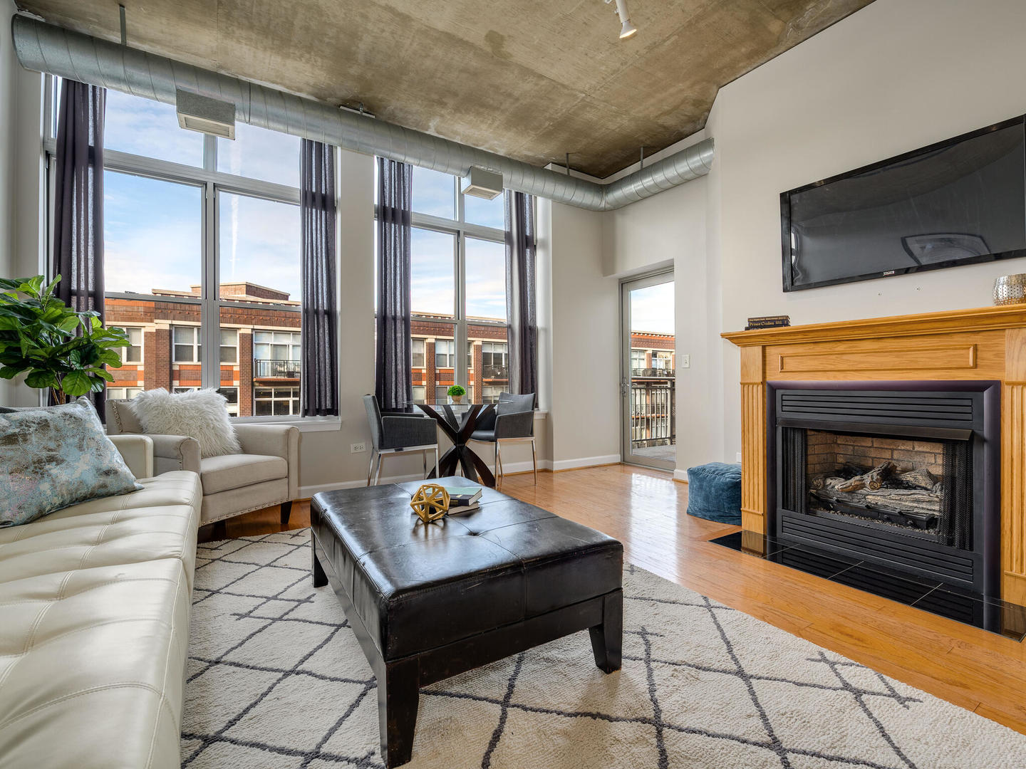111 South Morgan Street, Unit 811 Chicago, IL 60607 - Photo 10 of 21 a living room with furniture a fireplace and a flat screen tv
