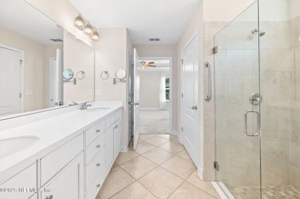 a spacious bathroom with a double vanity sink mirror and shower