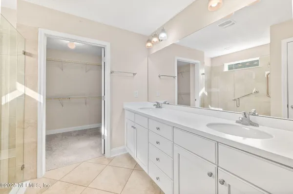 a bathroom with a double vanity sink and mirror