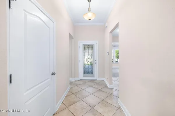 a view of a hallway with wooden floor and a chandelier