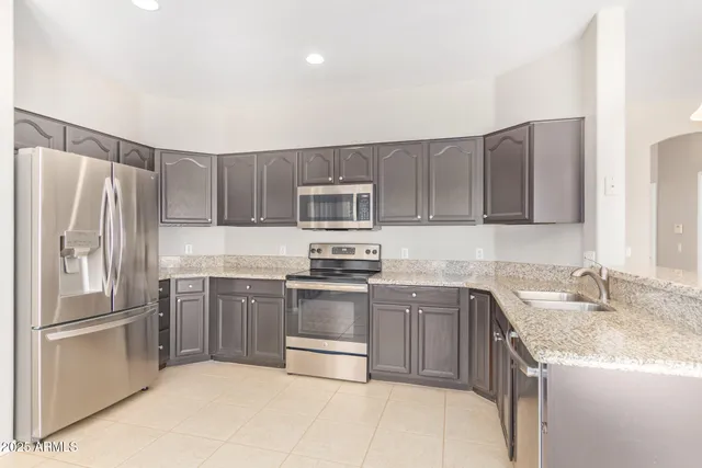 a kitchen with stainless steel appliances granite countertop a sink stove and refrigerator