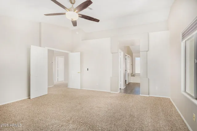 a view of a big room with wooden floor and a ceiling fan