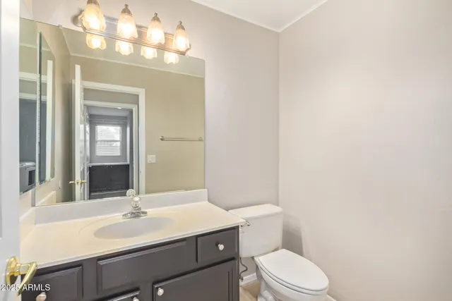 a bathroom with a sink vanity mirror and toilet
