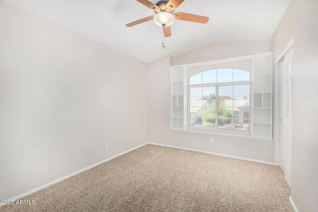 an empty room with windows and fan